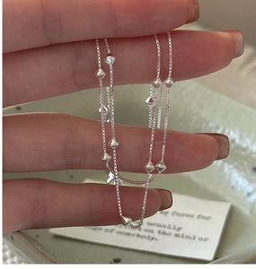 Close-up of a delicate S925 silver box chain necklace with geometric faceted bead accents