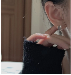 Detail view of S925 sterling silver aquamarine earrings worn by a model in soft lighting