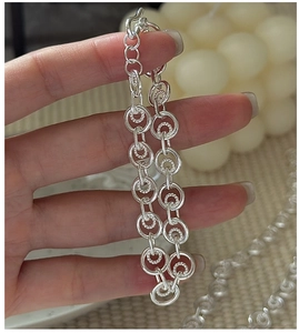 Macro detail of S925 silver bracelet showing textured interlocking circular links on wrist