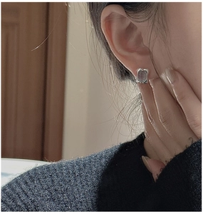 Close-up of S925 sterling silver earrings with rectangular aquamarine stones on ear