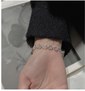 Detail of silver S925 interlocking circles bracelet worn on a woman's wrist