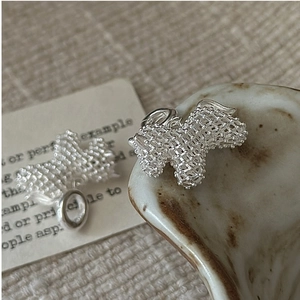 Macro shot of silver hollow horse charms with intricate woven texture and ring clasp