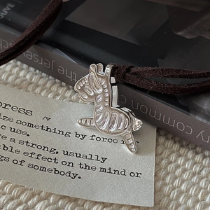 S925 sterling silver zebra pendant with vintage brown cord necklace on minimalist background