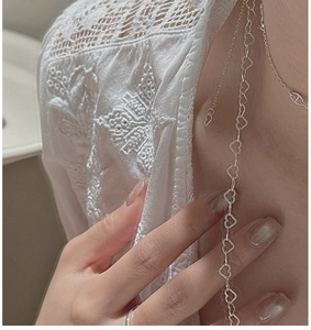 Close-up of S925 sterling silver heart-shaped link necklace with hollow heart pendants