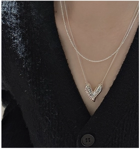 Detail of layered S925 sterling silver necklace with 3D diamond-pattern heart pendant