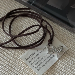 S925 sterling silver zebra pendant necklace with brown leather cord on knit background