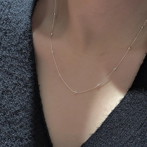 Collier minimaliste en argent S925 doré avec perles de bambou porté sur la clavicule