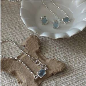 Macro shot of S925 silver jewelry set featuring oval aquamarine gemstones and bead chains