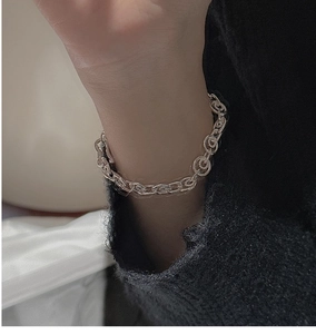 Detail of S925 sterling silver chain bracelet featuring textured round and oval links