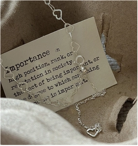 Close-up of S925 sterling silver heart link necklace with matte frosted texture finish