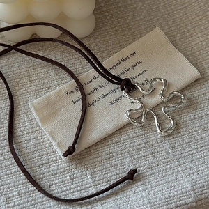 S925 sterling silver wavy flower pendant necklace with long brown suede cord on tabletop