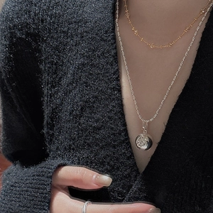 S925 sterling silver layered necklace with starburst pendant on black knit cardigan