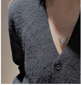 Close-up of heart pendant necklace with hammered texture finish on model