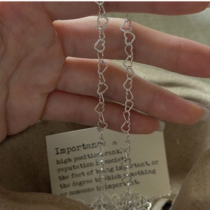 Detailed close-up of S925 silver heart-shaped chain links with shimmering matte texture
