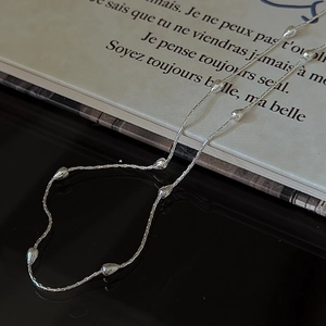 Collier minimaliste en argent S925 avec perles sur fond de livre français vintage