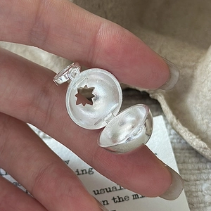 Handheld view of S925 sterling silver hollow sphere pendant with star pattern