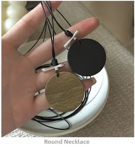 Détail de pendentifs ronds en bois avec cordon noir et fermoir en T en métal argenté