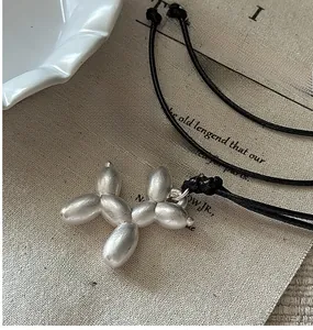 Gros plan d'un pendentif chien ballon en argent mat sur un sac en lin naturel