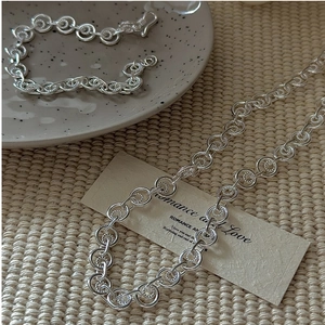 Detailed close-up of S925 sterling silver retro interlocking ring necklace and bracelet set