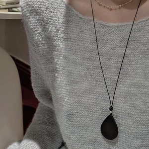 Minimalist S925 silver black teardrop pendant necklace layered over a grey knit sweater