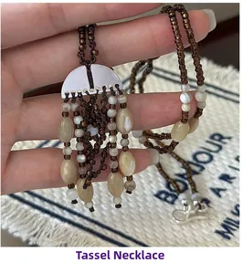 Detail of bohemian tassel necklace with silver metal clasp and coffee-colored beads