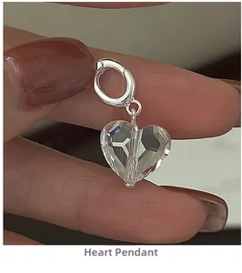 Macro shot of faceted crystal heart pendant with silver clasp held in hand