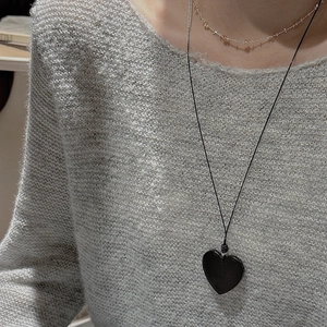 Minimalist S925 silver black heart pendant necklace on a grey knitted sweater