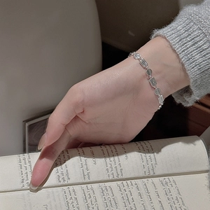Minimalist S925 sterling silver geometric link bracelet with matte finish on book background