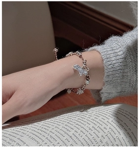 Vue détaillée du bracelet en argent S925 avec perles et breloque papillon ajourée au poignet