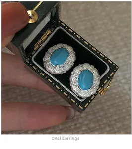 Detail of oval turquoise earrings with silver textured frames in a vintage jewelry box