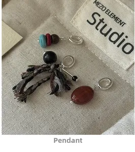 Close-up of vintage S925 silver handmade fabric pendants with turquoise and woven tassel