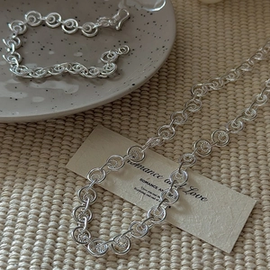 S925 sterling silver interlocking circle bracelet with spiral texture on ceramic plate
