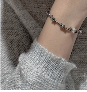 Dettaglio di un bracciale artigianale in corda con perline in argento S925 indossato al polso