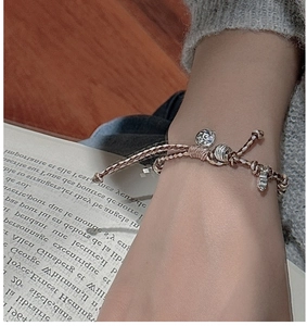 Détail d'un bracelet tressé vintage avec pendentif soleil argenté sur corde