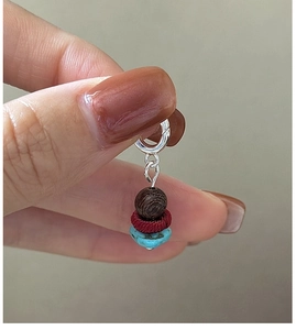 Macro detail of S925 silver pendant with wood bead, red accent and turquoise stone