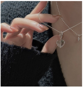 Macro shot of S925 silver heart necklace with faceted crystal pendant on model