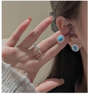 Close-up of S925 silver turquoise stud earrings and matching ring on model