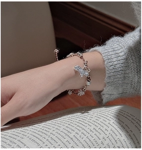 Détail du bracelet en argent S925 avec breloques papillon et cœur sur cordon tressé