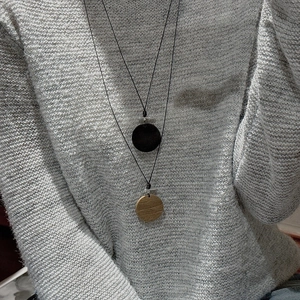 Collier minimaliste en argent S925 avec pendentifs en bois et noir sur un pull-over