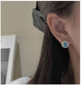 Detail of S925 silver turquoise stud earring with vintage lace texture on model