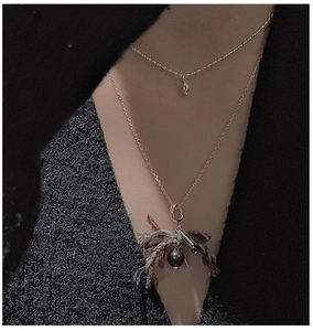 Close-up of double-layer S925 silver necklace with teardrop pendant and woven hemp details