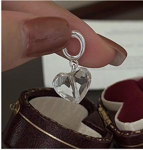 Macro shot of faceted heart crystal pendant with silver loop on vintage red velvet