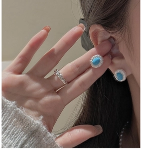 Close-up of S925 silver turquoise earrings with crystals and textured ring on model