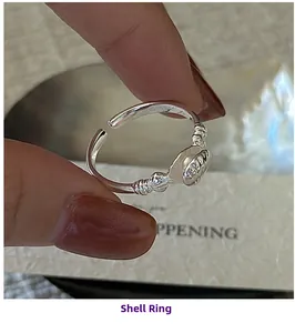 Detailed close-up of S925 sterling silver shell ring with pearl accent on model hand