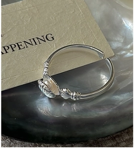 Detailed macro view of S925 sterling silver shell ring with pearl on iridescent tray