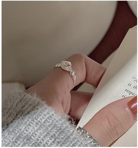 Detail of S925 sterling silver shell textured ring worn on model for a chic look