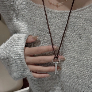 S925 sterling silver key pendant on dark brown cord necklace with gray knitted sweater