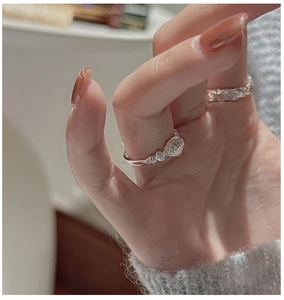 Detail view of S925 sterling silver shell texture ring set worn on model's hand