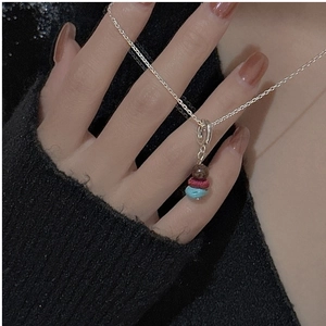 Detail of S925 sterling silver necklace with three-color layered beads on black knit fabric