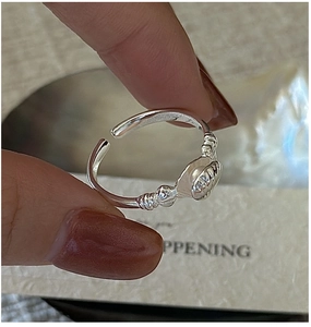 Macro shot of S925 silver shell ring featuring an elegant pearl on adjustable band